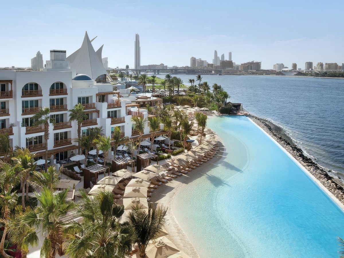 Park Hyatt Dubai&rsquo;s whitewashed blocks and blue dome above a curved sand-edged pool on Dubai Creek
